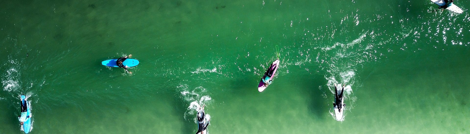 Surfers in clear green water